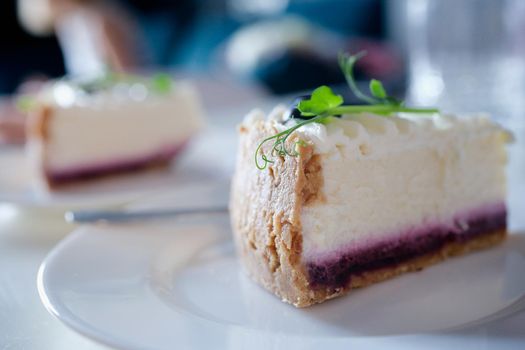 Piece of delicious cottage cheese cake with jam on plate. Sweet calorie cake concept