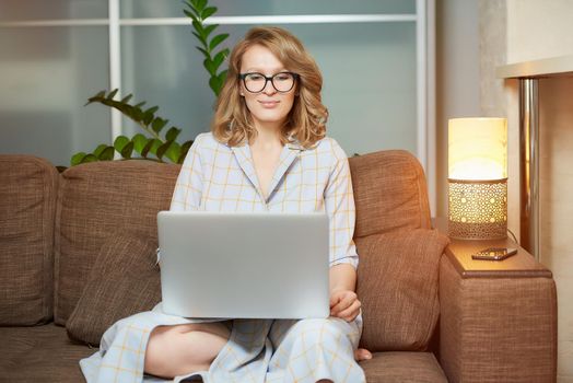 A woman in glasses works remotely on a laptop in her apartment. A girl during a video conference with her colleagues at home. A female student with braces listening to an online lecture.