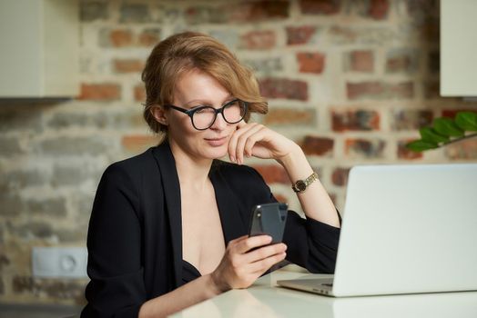 A young woman in glasses working remotely on a laptop in a cafe. A blond lady using a smartphone at home. A female teacher searching for information on a cellphone..