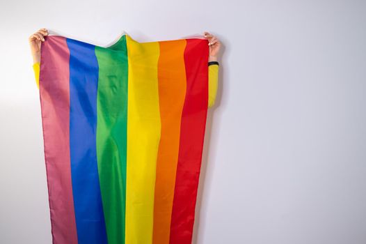 Caucasian woman holding lgbt flag covering herself