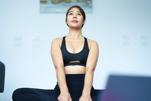 stress relief, muscle relaxation, breathing exercises, exercise, meditation, portrait of Young Asian woman relaxing her body from office work by practicing yoga by watching online tutorials