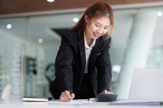 accountant, Auditor, Self-Employed, Finance and Investment, tax calculation and budget, Portrait of Asian female entrepreneur using a calculator to calculate. Company business results document