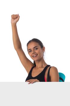 Attractive positive young sportswoman holding blank board banner isolated on white background