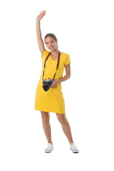 Beautiful woman photographer in yellow dress with photo camera. Full length portrait. Isolated on the white background.