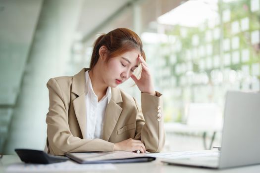 Burnout Syndrome. Portrait of Asian Business Woman feels uncomfortable working. Which is caused by stress, accumulated from unsuccessful work And less resting body. Consult a specialist psychiatrist