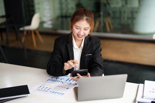 accountant, Auditor, Self-Employed, Finance and Investment, tax calculation and budget, Portrait of Asian female entrepreneur using a calculator to calculate. Company business results document