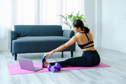 stress relief, muscle relaxation, breathing exercises, exercise, meditation, portrait of Young Asian woman relaxing her body from office work by practicing yoga by watching online tutorials