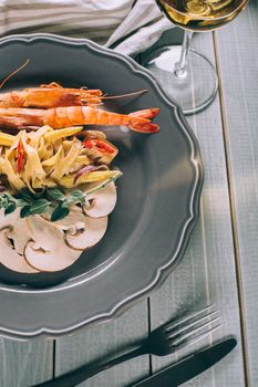 Noodles with shrimp and mushrooms. The original presentation of the dish from the chef. Spaghetti