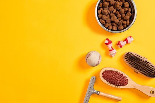 Accessories for the grooming of the dog on yellow background. Combs and brushes for dogs. Top view. Still life. Copy space. Flat lay