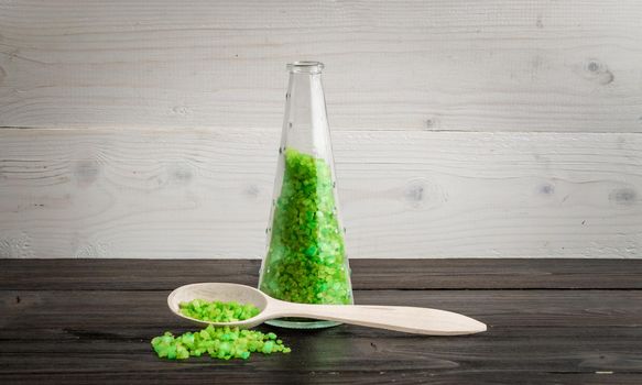 Green bath salt for spa on wooden spoon. SPA. Still life. Copy space