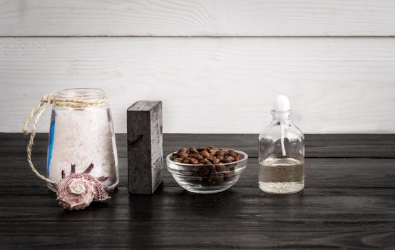 Spa still life. Aroma oils, stones, soap, sea salt and coffee beans on wooden background. Various bath accessories. Items for the spa. Copy space