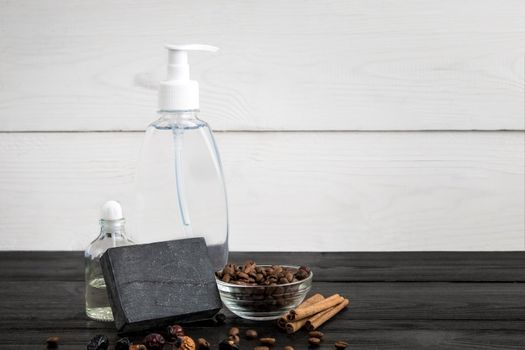 Spa still life. Aroma oils, stones, soap, shampoo and coffee beans on wooden background. Various bath accessories. Items for the spa. Copy space