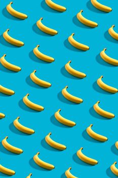 Colorful pattern of bananas on sky blue background. Still life