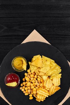 Wide selection of snacks for beer with different sauces on parchment top view. Copy space. Still life. Flat lay