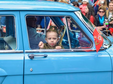 PYATIGORSK, RUSSIA - MAY 09, 2017: A little boy in uniform for the day of victory in a GAZ-21 Volga.Celebration of anniversary of the Victory Day WWII