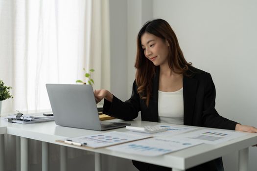Asian accountant or financial expert analyze business report graph and finance chart at corporate office. Concept of finance economy, banking business and stock market research