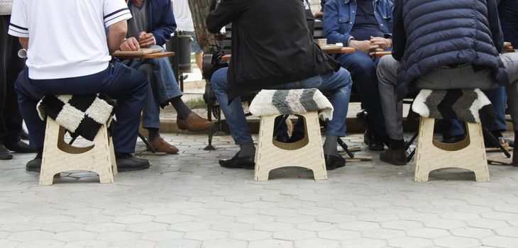 Caucasian men play backgammon on the street