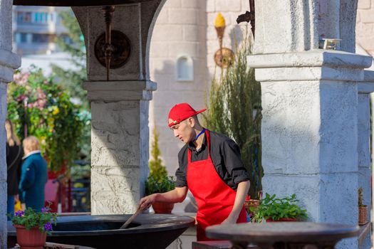 A man prepares an oven in a street cafe for cooking. Moscow Russia April 23, 2022.