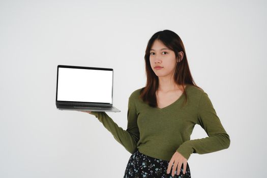 young asian girl holding a laptop and show blank white sreen, isolated on white background.