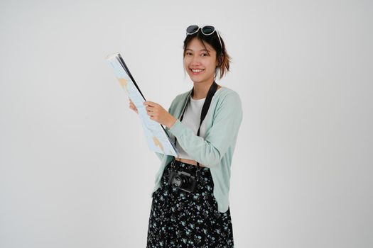 Traveler exploring dreamful tourist asian woman in casual clothes hat camera hold paper map during excursion isolated on white background