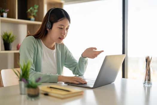 Online learning, portrait of happy asian female freelancer or smiling woman student using a laptop for a video call with a teacher, distance education concept.