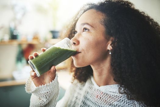 Young girl drinking green smoothie