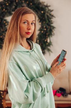 A woman with a phone in her hands. A woman with long hair shows an application on a mobile phone