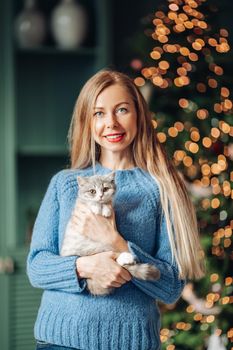 A woman with a cat hugs at home