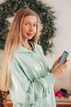 A woman with a phone in her hands. A woman with long hair shows an application on a mobile phone