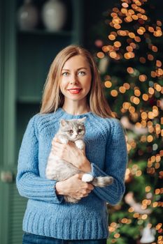 A woman with a cat hugs at home