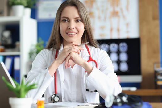 Portrait of smiling female doctor in gown, young medical specialist working in clinic. Healthcare, medicine, emergence and save life concept