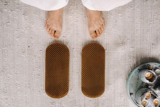 The man's feet are next to boards with nails. Yoga classes.