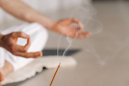 Close-up of a man in white sportswear doing yoga in a fitness room with a balgovon. the concept of a healthy lifestyle.