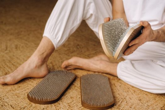 A man holds in his hands boards with nails for yoga classes.