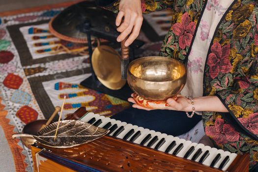 Tibetan singing bowl in the hands of a man during a tea ceremony.