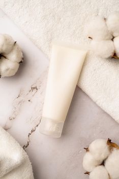 Mockup facial skincare product white tube with blank label on marble background, Top view