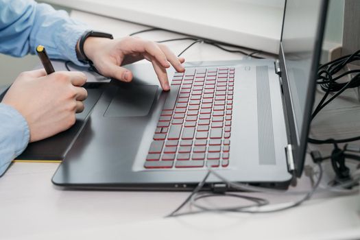 Graphic designer using digital tablet and computer in office. hands close up