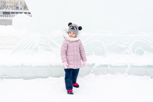 playful child girl happy in snow town on winter day