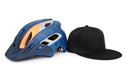 Bike helmet and a baseball snapback hat side by side, isolated on white background. Fashion and head accessories concept.