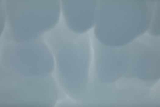 During unusually strong winds, clouds accumulate and gather into irregular bubbles. Close up frame of a slice of the sky.