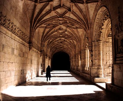 A girl walking in a cloister in Jeronimos Monastery in Lisbon