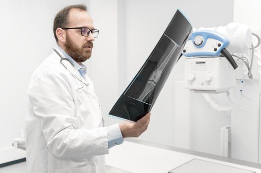 Doctor examine a film x-ray of a patient at radiology room. High quality photography.