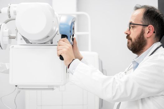 Doctor operating X-ray machine in radiology department. High quality photography