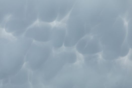 During unusually strong winds, clouds accumulate and gather into irregular bubbles. Close up frame of a slice of the sky.