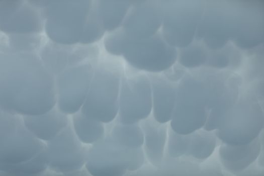 During unusually strong winds, clouds accumulate and gather into irregular bubbles. Close up frame of a slice of the sky.