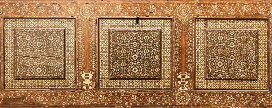 Antique art of wood decoration on a 15th century Italian furniture. Vintage and gothic background image.