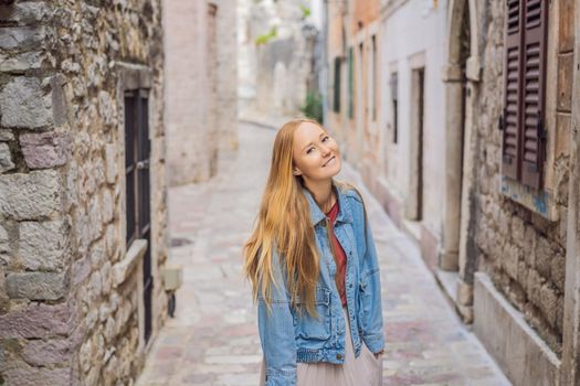 Woman tourist enjoying Colorful street in Old town of Kotor on a sunny day, Montenegro. Travel to Montenegro concept.