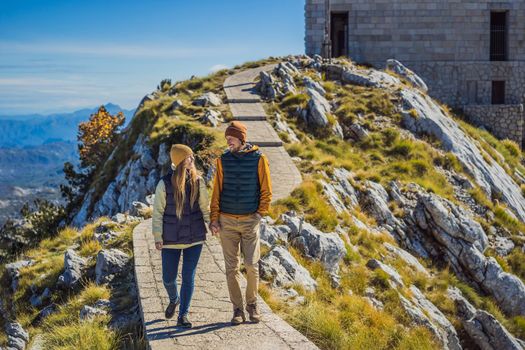 Couple man and woman tourists in mountain landscape at national park Lovcen, Montenegro. Travel to Montenegro concept.