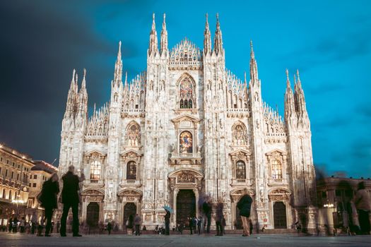 Milan Cathedral - Duomo di Milano - is the gothic cathedral church of Milan, Italy. Shot in the dusk from the square ful of people.