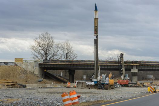 Construction for renewing damages on pillars of concrete bridge of a under renovation road modern road interchange in USA